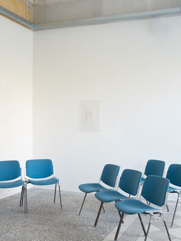 undefined, Metrica No. 5, 2026, 2026, Three-channel video installation with 5-channel audio, 20m TRT, Shot and performed on location in 2025, the artwork follows three psychotherapists as they enter the storage rooms of the Martynas Mažvydas National Library of Lithuania. Surrounded by shelves of documents, the women at the center of the performance score listen, question, and respond as the archive attempts to describe its fears and desires. Critical questions of selfhood, consciousness, and collective experience form and unravel as the sessions reflect upon the procedures of psychotherapy as they might apply to a subject whose “mind” is composed of an unfathomable mass of undead human writing. 

This new work is also part of Metrica, an evolving series of performances that stage encounters between public archives, psychoanalysts, and artificial intelligence, initiated by the artist duo in 2023 during their first stay in Vilnius at the Rupert residency programme. Their initial interest in land ownership histories in the region led Benedict and Rueter to two distinct repositories within Lithuanian history: the books of the Lithuanian Metrika—foundational administrative records of the 13th–17th century Duchy of Lithuania, held in 200 codices that have all been removed from Lithuania (the existing volumes are now in Moscow)—which have been digitized in a limited way by historians at Vilnius University; and oral histories of the 1990s post-Soviet Lithuanian administrative processes, developed by the newly independent state to re-privatize and repatriate land, which eventually resulted in a new digital government land register. Out of encounters between these archives, the artists, and artificial intelligence systems, the Metrica series produces a variety of conversational forms that engage what might be understood as the institutional unconscious.

For the most recent performances (Metrica No. 5-7, 2025 – ongoing), Benedict and Rueter invite professional psychotherapists to conduct intake sessions with the “psyches” of public archives. Voiced through an AI agent engineered by the artists, the archival psyches draw from historical land records, administrative documents, and literary texts – official records recast as personal memories. 

