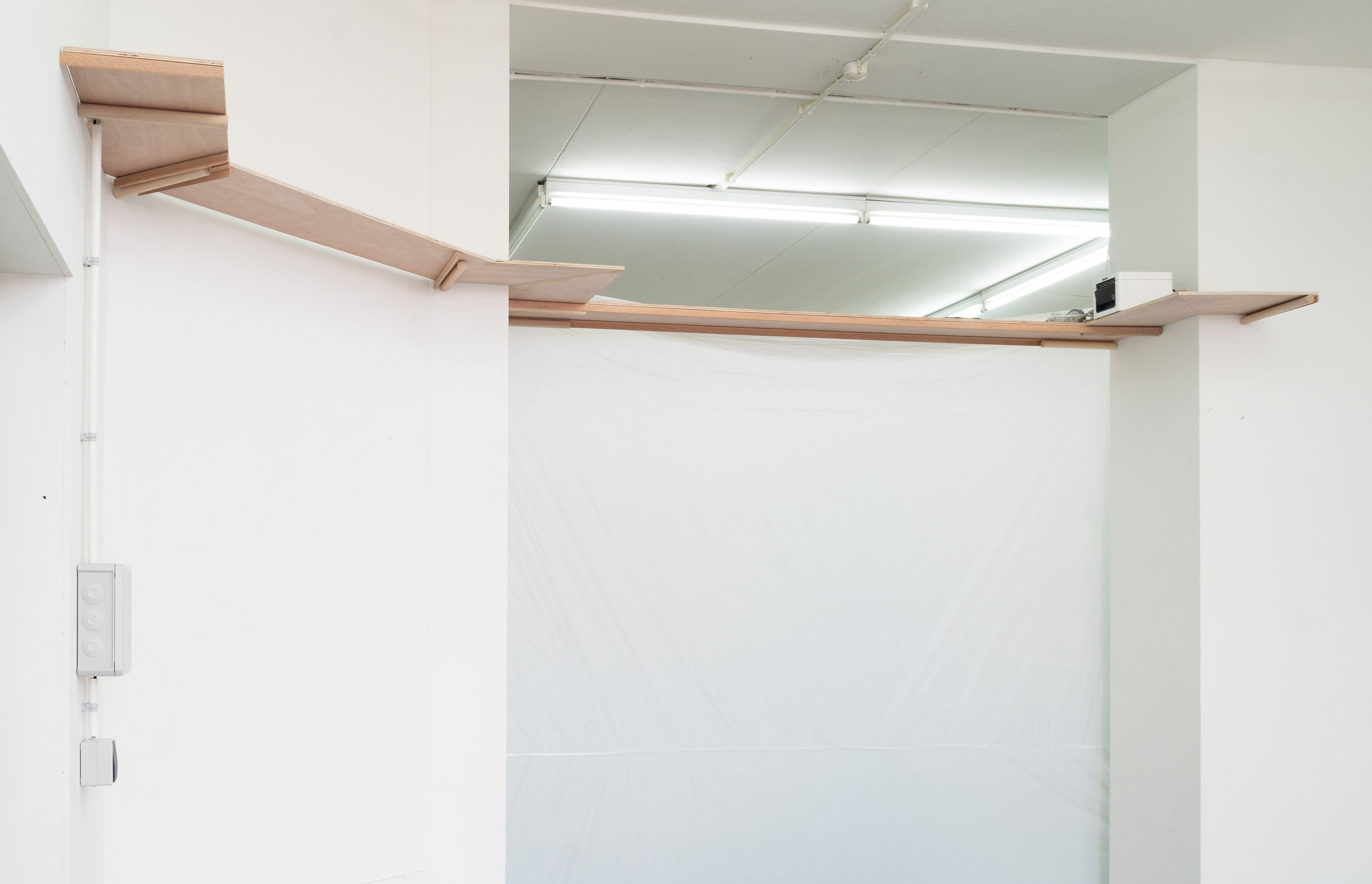 Marissa Lee Benedict and David Rueter, a conversation between machines about Mallarmé (regarding the state of the gallery lights), 2023, Wooden shelf, receipt printer, thermal paper, wiring and conduit, custom software, annotated text file containing Stéphane Mallarmé's poem "Un coup de dés jamais n'abolira le hasard," Large Language Model (LLM) cloud service account, single-board computer., Dimensions Variable